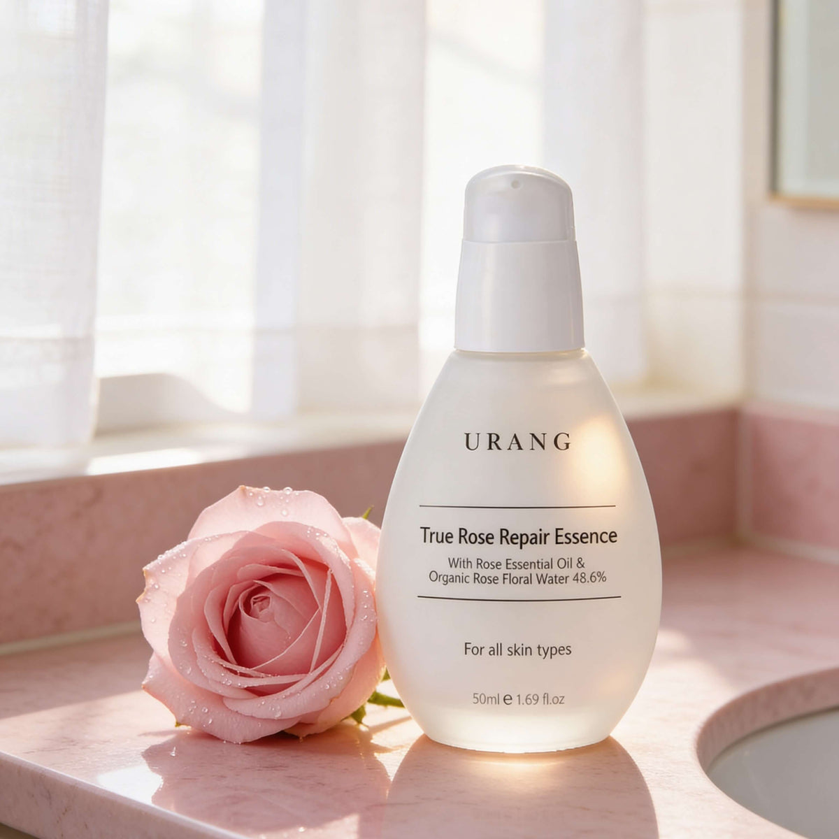 Urang True Rose Repair Essence, flacone in ambientazione con rose