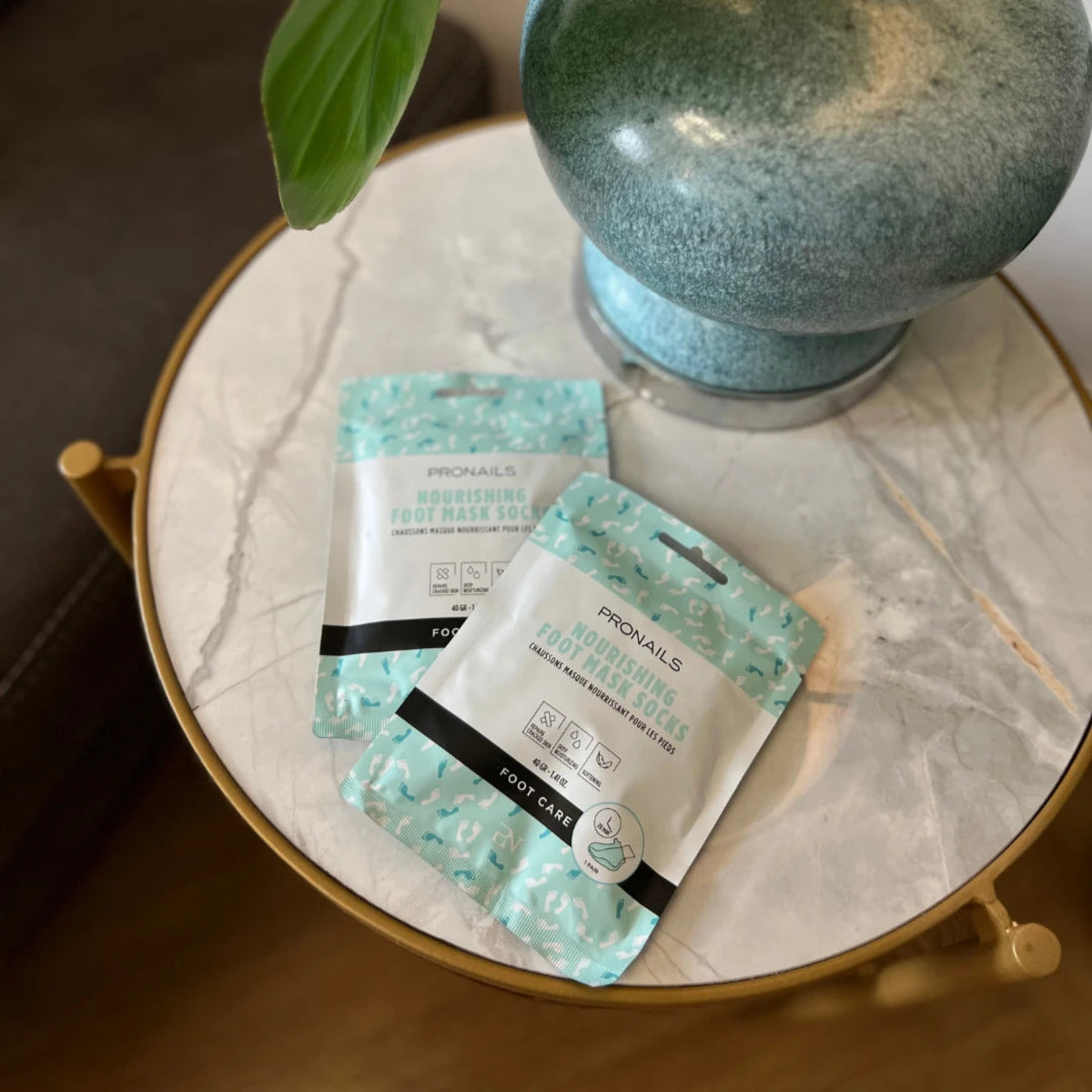 ProNails Nourishing Foot Mask Socks, due bustine su tavolino con vaso decorativo