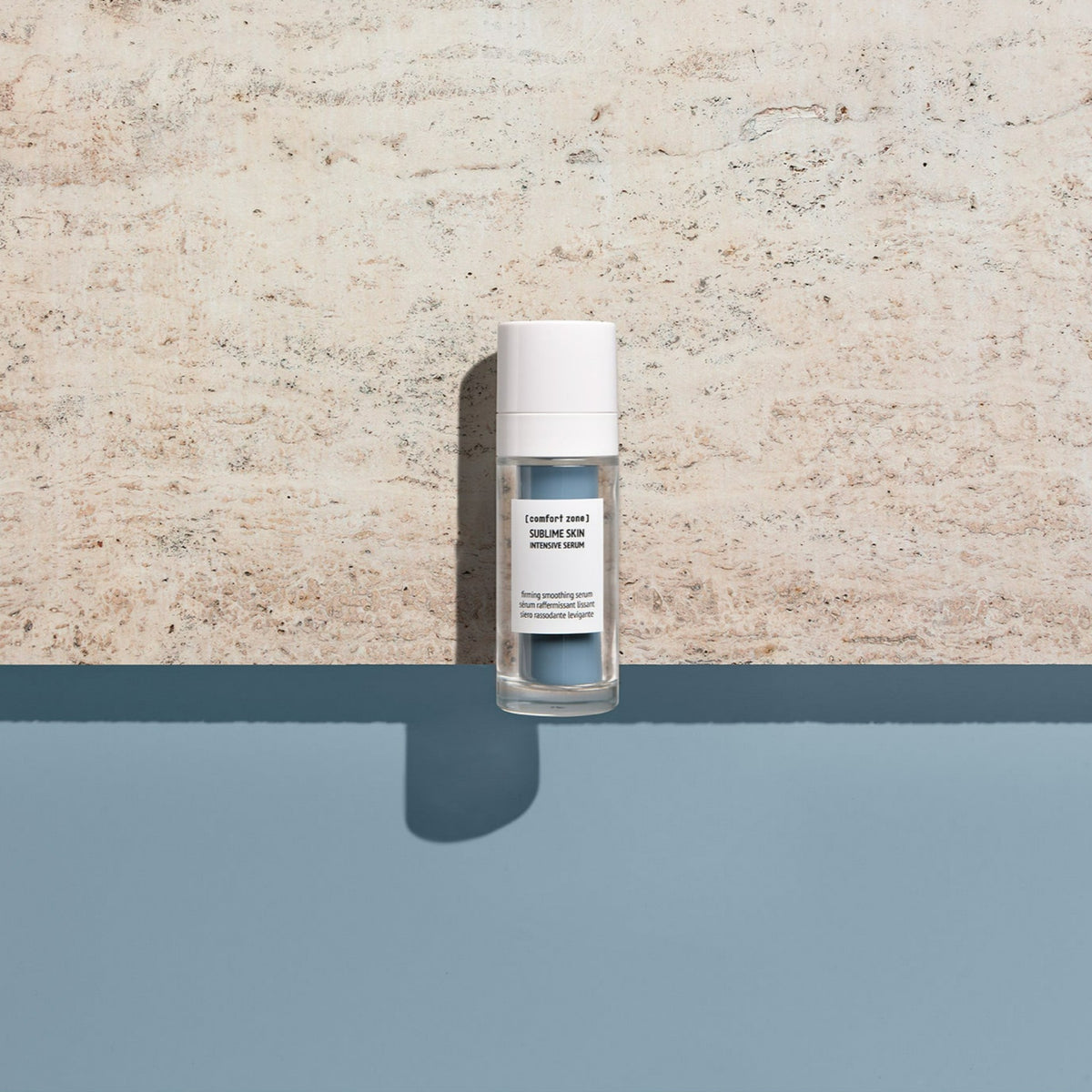 Comfort Zone Sublime Skin Intensive Serum, flacone su sfondo marmo e acqua azzurra